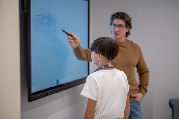 Lærer underviser elev ved smartboard