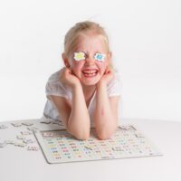 Barn der leger med brikkerne fra 1-100-puslespillet
